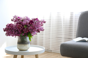 Flower vases sitting inside of window - blooming shrubbery and spring scenery outside of window.
