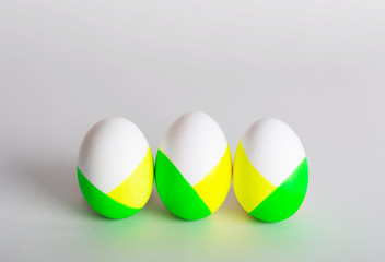 Three in a row easter eggs on a gray concrete background