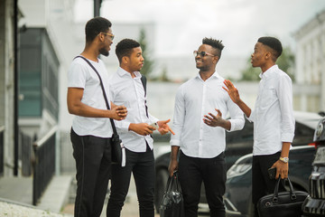 four handsome young african men in white shirts
