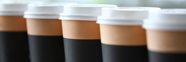 Paper cup line standing at table ready to be taken away close-up