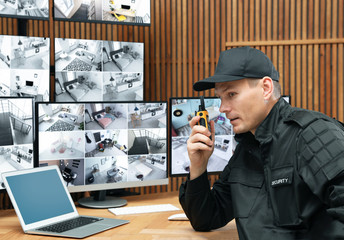 Security guard using portable transmitter at workplace in office