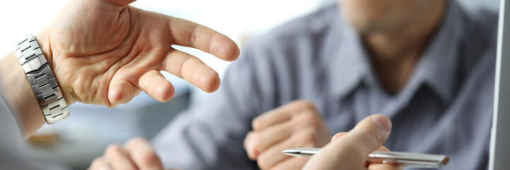 Naklejka premium Close-up of gesturing male hands. Businessman explaining project details to partner in office. Conference of people brainstorming on development of company. Boss and employee wearing watch