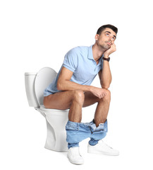 Man sitting on toilet bowl, white background