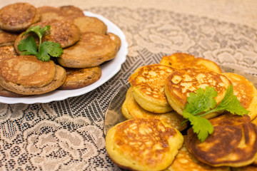 Pancakes from chickpea and wheat flour with celery leaves lie on the plates