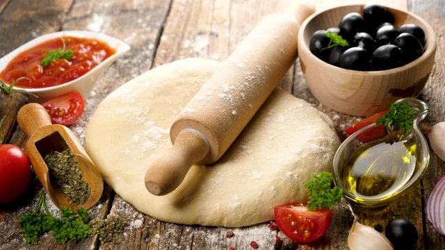 cooking pizza with cheese, tomato, olive on wood background