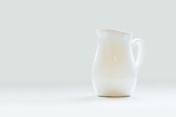 White porcelain milk jug on white background. Pitcher