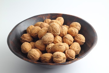 Walnuts isolated on white background. Heap of walnuts isolated on white background. Walnut in a wooden bowl on white background. Walnuts with copy space for text.