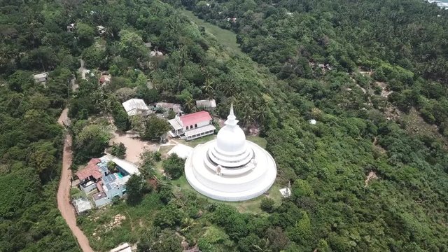 A large white pagoda on top of a mountain. Aerial drone View