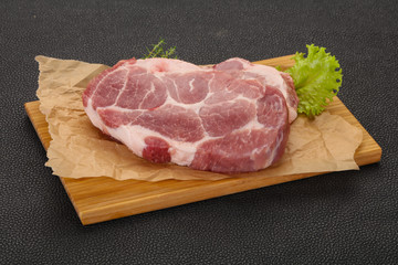 Raw pork steak over wooden board