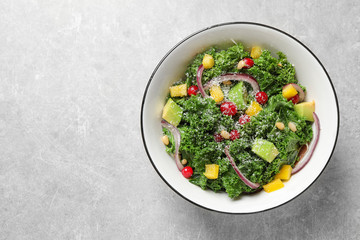 Tasty fresh kale salad on light grey table, top view