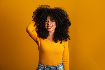 Young afro-american woman with curly hair looking at camera and smiling. Cute afro girl with curly...