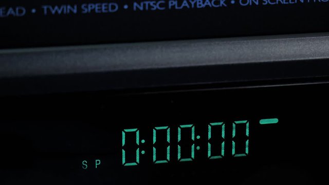 Close-up of insert an vintage analog VHS video cassette into VCR /counter 4k
