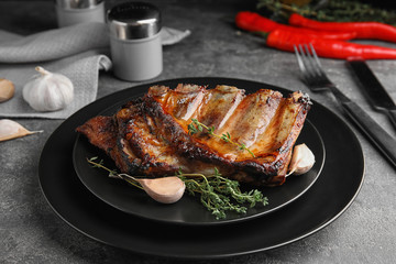 Tasty grilled ribs with thyme on grey table
