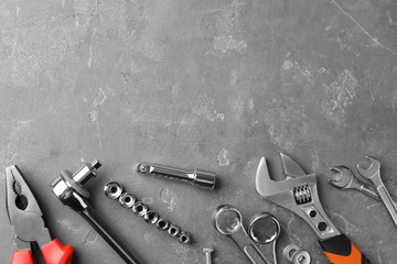 Auto mechanic's tools on grey stone table, flat lay. Space for text