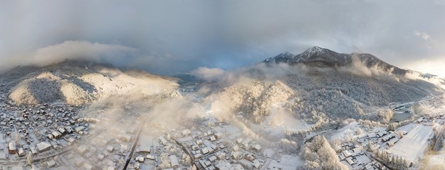 Aerial view of Krasnaya Polyana, mountains covered by snow and beautuful clouds. Russia.