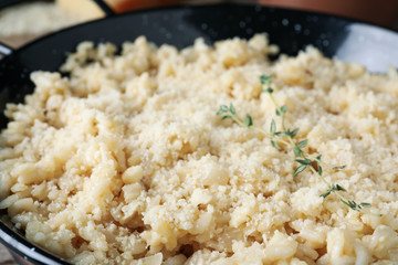 Delicious risotto with cheese in pan, closeup