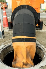 Pipe from water pumping machine pump out water for drainage to culvert from flooded area.