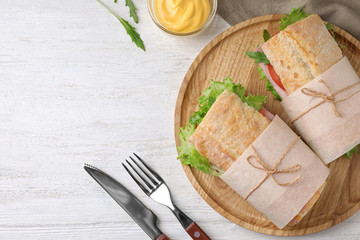 Tasty sandwiches with ham served on white wooden table, flat lay