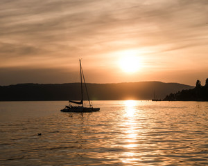 Sailboat on lake while sunset