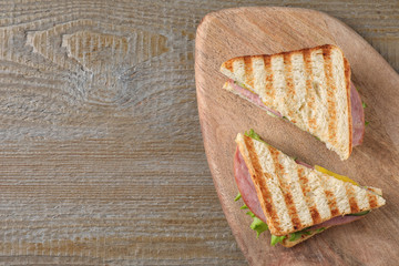 Tasty sandwich with ham on wooden table, top view. Space for text