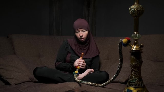 woman intoxicated after smoking hookah in living room on couch.