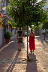 Fototapeta na wymiar two women walk into the sunset through a spanish old town 