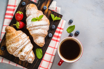 Croissant with fresh berries and cup of coffee.