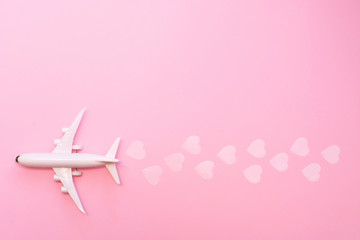 Happy Valentines day. white plane on a pink background with hearts