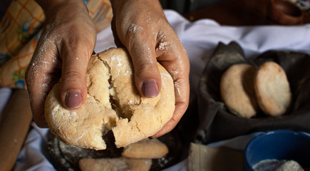 manos de mujer partiendo pan casero recién horneado