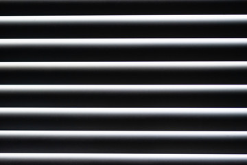 a closeup of closed accordion style blinds on a sunny day 