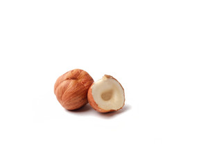 one peeled hazelnut core and half a nut close-up, isolate white background