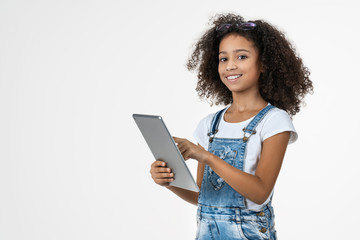 African preteen girl using tablet computer playing game isolated on white background