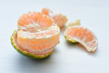  Natural, whole, chopped tangerines on wooden background