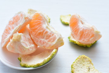 Natural, whole, chopped tangerines on wooden background