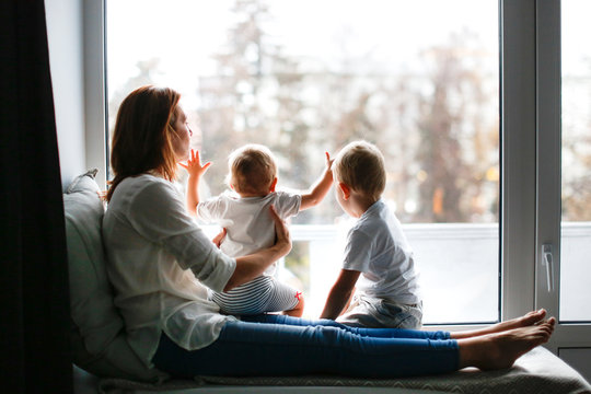 mother with two children at window in evening