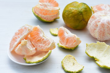 Natural, whole, chopped tangerines on wooden background