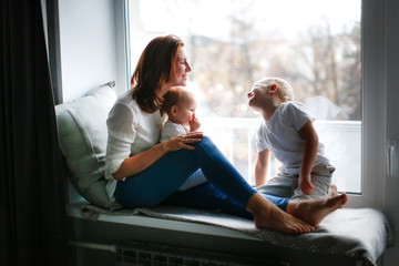 mother with two children at window in evening