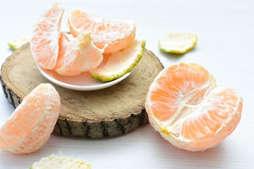  Natural, whole, chopped tangerines on wooden background