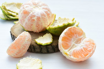  Natural, whole, chopped tangerines on wooden background
