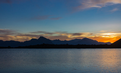 atardecer a orilla de una laguna con vista a las montañas
