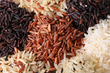 Different types of brown and polished rice as background, closeup