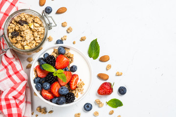 Greek yogurt granola with fresh berries on white table.