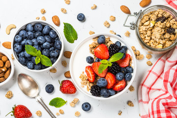 Greek yogurt granola with fresh berries on white table.