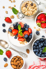 Greek yogurt granola with fresh berries on white table.