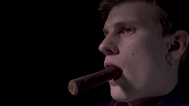 A young man with a cigar at a card table in a casino. Moving camera. 4K