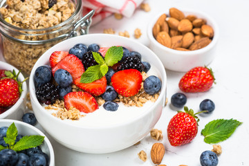 Greek yogurt granola with fresh berries on white table.