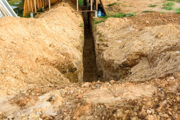 Digging a trench. Earthworks, digging trench. Long earthen trench dug to lay pipe or optical fiber.