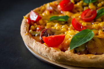 Pizza with tomatoes and basil close-up