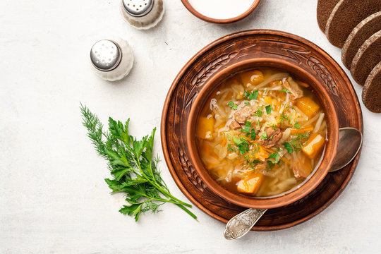 Traditional russian cabbage soup with turnip shchi in ceramic bowl on concrete background. Top view.
