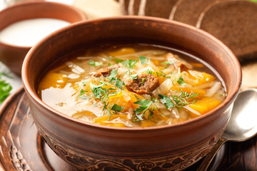 Traditional russian cabbage soup with turnip shchi in ceramic bowl on concrete background. Selective focus.